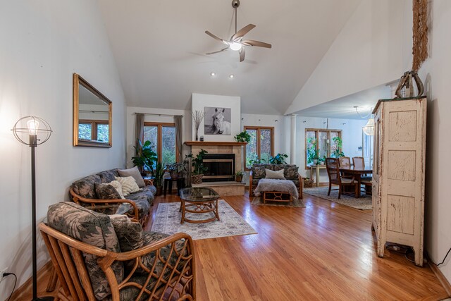 living room featuring ceiling fan, high vaulted ceiling, a healthy amount of sunlight, and wood-type flooring