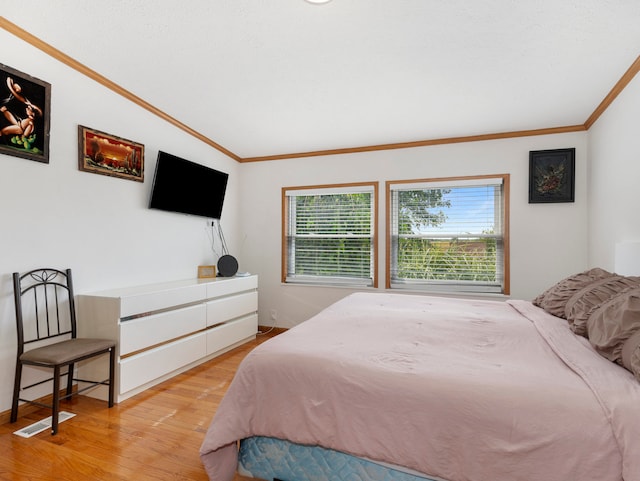 bedroom with light wood-type flooring and ornamental molding