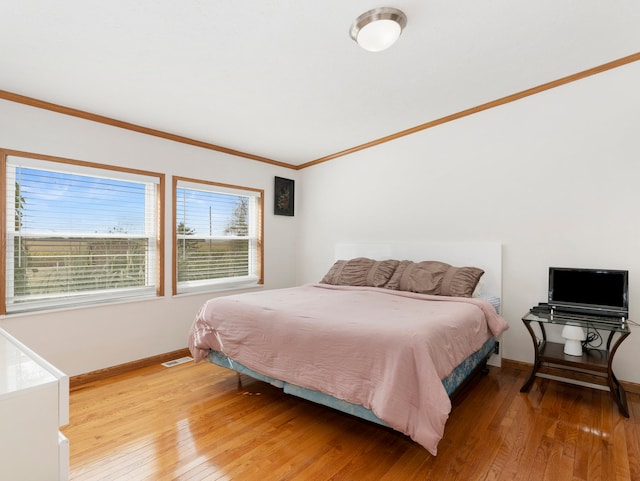 bedroom with crown molding and light hardwood / wood-style flooring