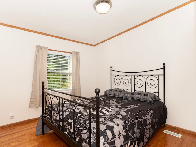 bedroom featuring hardwood / wood-style flooring and crown molding