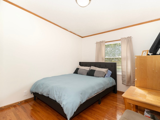 bedroom featuring wood-type flooring and ornamental molding