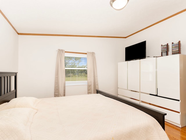 bedroom featuring ornamental molding and light hardwood / wood-style floors