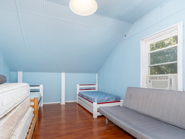 bedroom with dark hardwood / wood-style flooring, lofted ceiling, and cooling unit