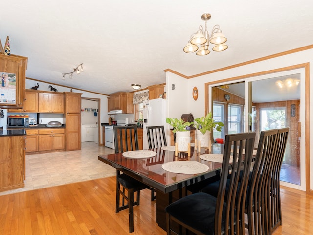 dining room with a textured ceiling, an inviting chandelier, crown molding, and light hardwood / wood-style flooring