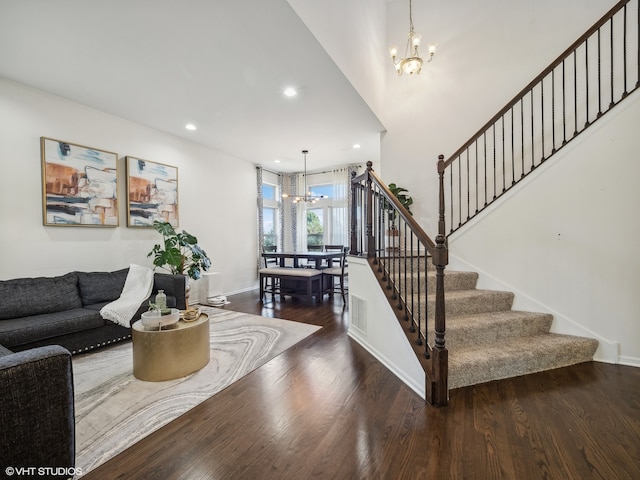 staircase with a chandelier and hardwood / wood-style flooring