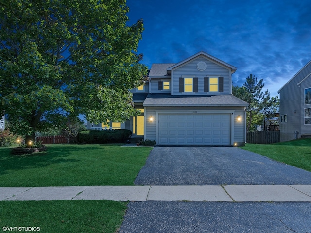 view of front facade featuring a garage and a yard