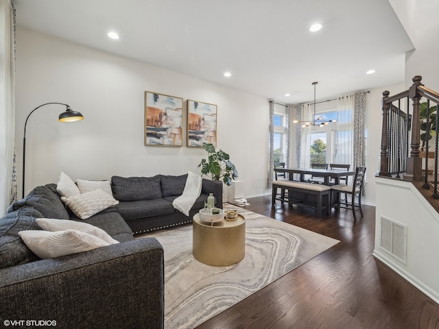 living room with dark hardwood / wood-style floors and a notable chandelier