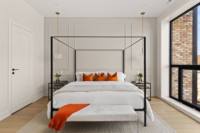 bedroom featuring multiple windows and light hardwood / wood-style flooring