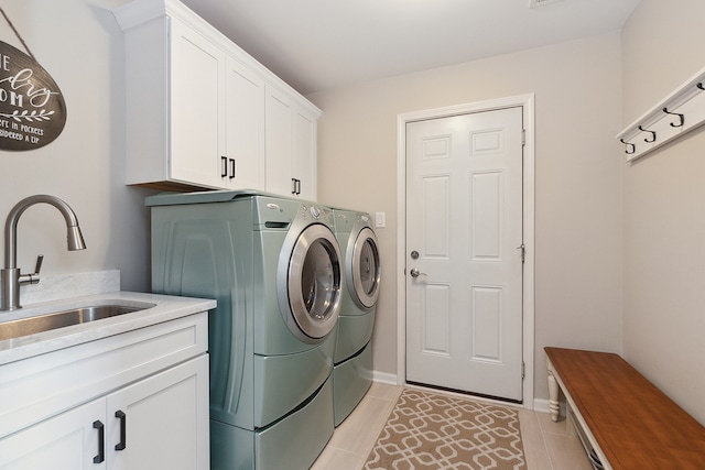 laundry room featuring cabinets, light tile patterned floors, sink, and independent washer and dryer