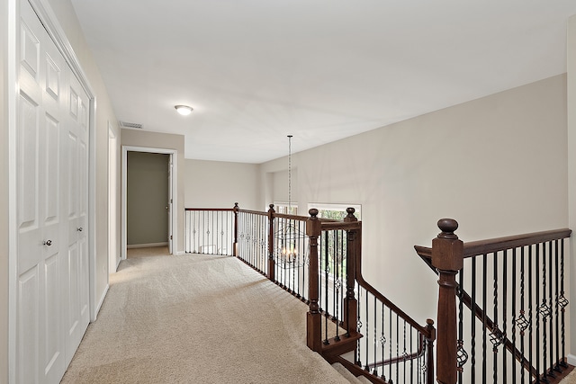 corridor featuring carpet flooring and an inviting chandelier