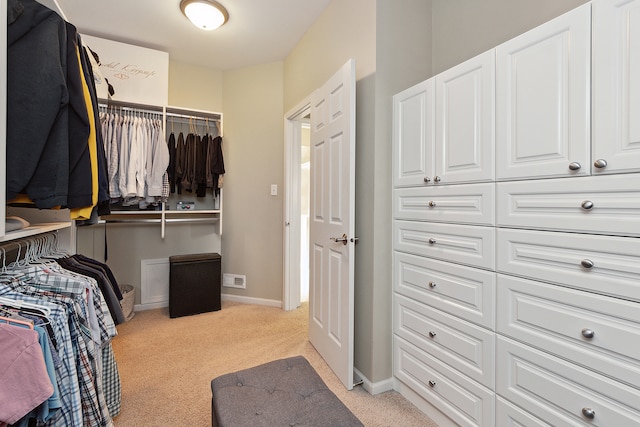 walk in closet featuring light colored carpet