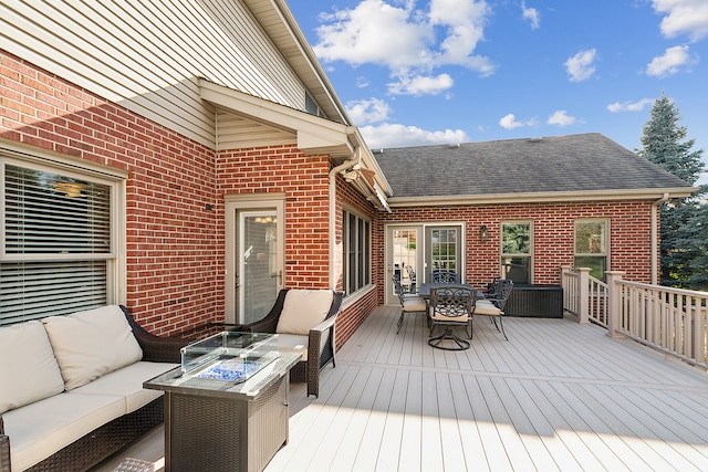 wooden terrace with an outdoor living space with a fire pit