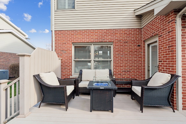 wooden deck featuring an outdoor living space with a fire pit and central AC