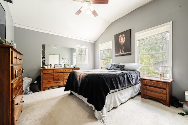 carpeted bedroom with ceiling fan, vaulted ceiling, and ornamental molding