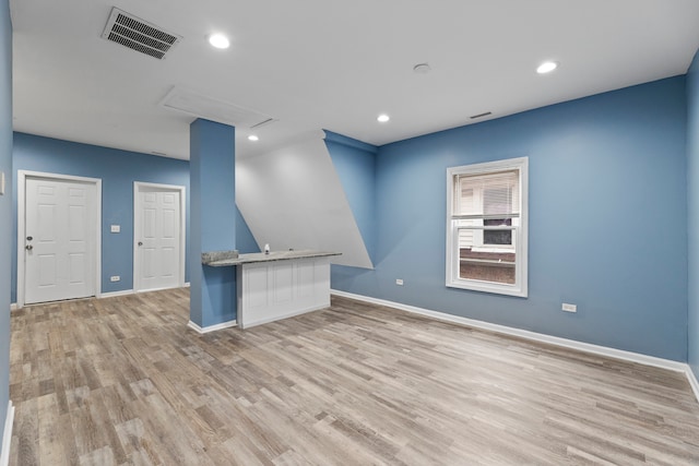 interior space with light wood-type flooring and kitchen peninsula