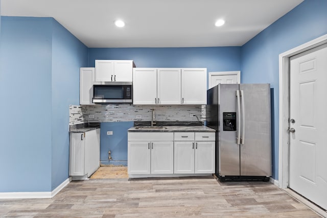 kitchen featuring stainless steel appliances, white cabinetry, sink, and decorative backsplash