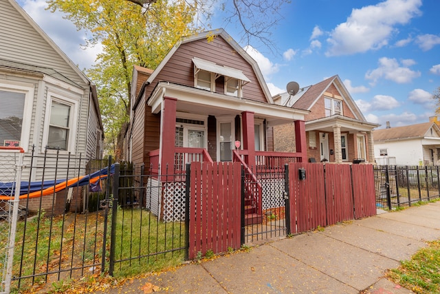 bungalow-style house with a front yard and covered porch