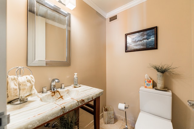 bathroom featuring toilet, vanity, and ornamental molding