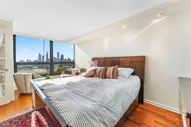 bedroom with dark hardwood / wood-style floors and crown molding