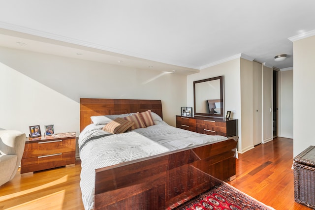 bedroom with ornamental molding and light wood-type flooring