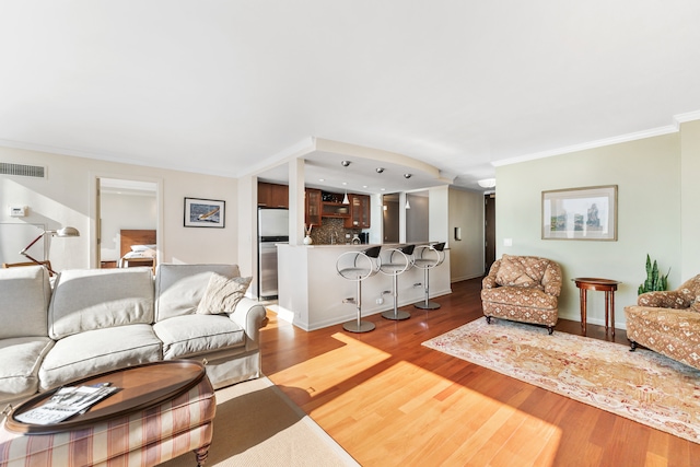 living room featuring hardwood / wood-style flooring and crown molding