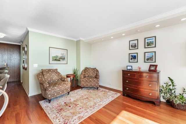 sitting room featuring wood-type flooring and ornamental molding