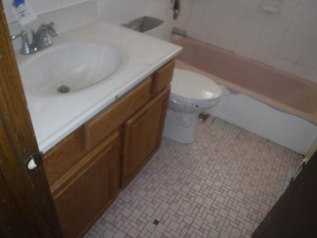 bathroom featuring tile patterned floors, vanity, toilet, and a tub