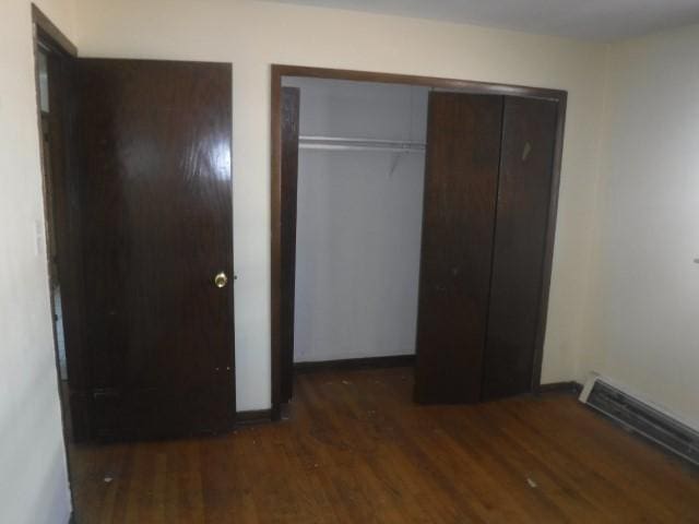 unfurnished bedroom with dark wood-type flooring