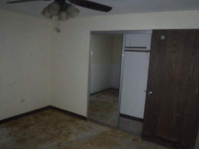 unfurnished bedroom with ceiling fan and a closet