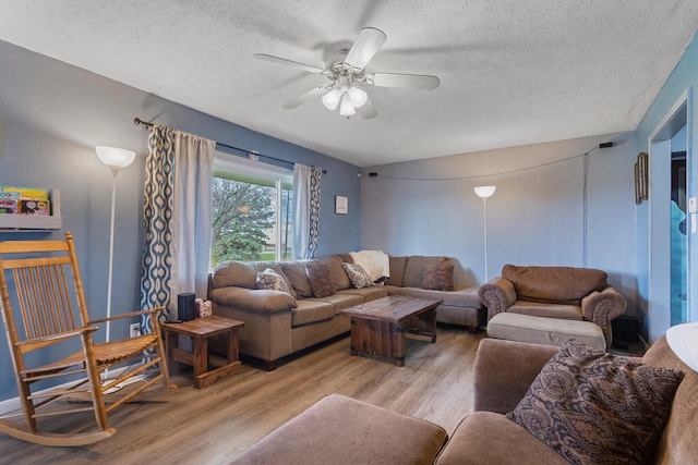 living room with a textured ceiling, light hardwood / wood-style floors, and ceiling fan