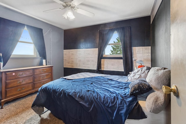 carpeted bedroom with ceiling fan and a textured ceiling