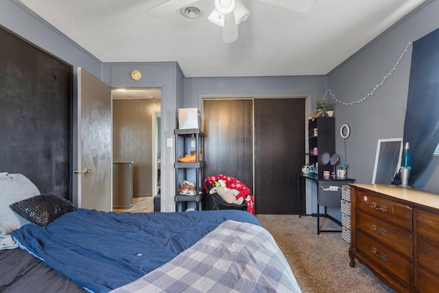 carpeted bedroom with ceiling fan, a closet, and a textured ceiling