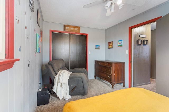 bedroom with ceiling fan, light colored carpet, and a textured ceiling