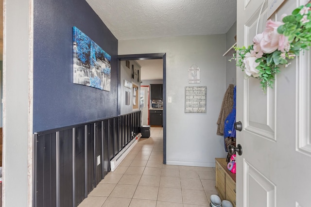 hallway with light tile patterned floors and a textured ceiling