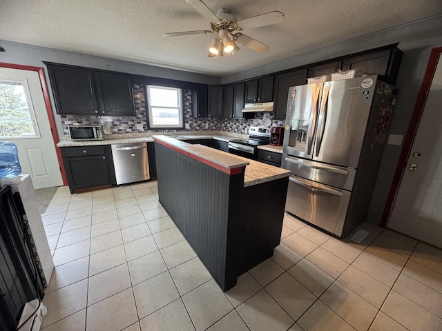 kitchen featuring tasteful backsplash, stainless steel appliances, a kitchen island, and a wealth of natural light