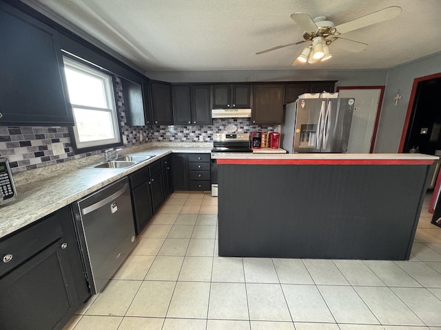 kitchen featuring decorative backsplash, appliances with stainless steel finishes, ceiling fan, sink, and a center island