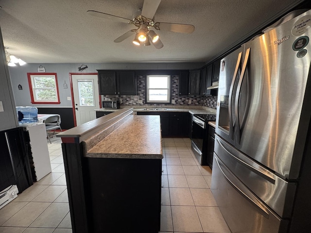 kitchen featuring a wealth of natural light, a kitchen island, appliances with stainless steel finishes, and tasteful backsplash