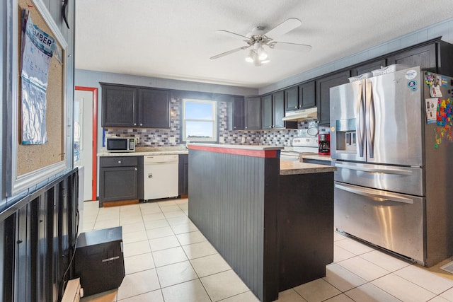 kitchen featuring decorative backsplash, a center island, light tile patterned floors, and stainless steel appliances