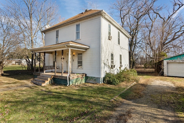 view of front of property featuring an outdoor structure, a garage, a porch, and a front yard