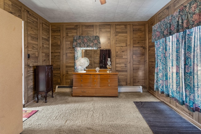 living area featuring ceiling fan, carpet floors, baseboard heating, and wooden walls