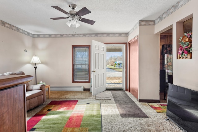 carpeted foyer entrance featuring ceiling fan, crown molding, a textured ceiling, and a baseboard heating unit