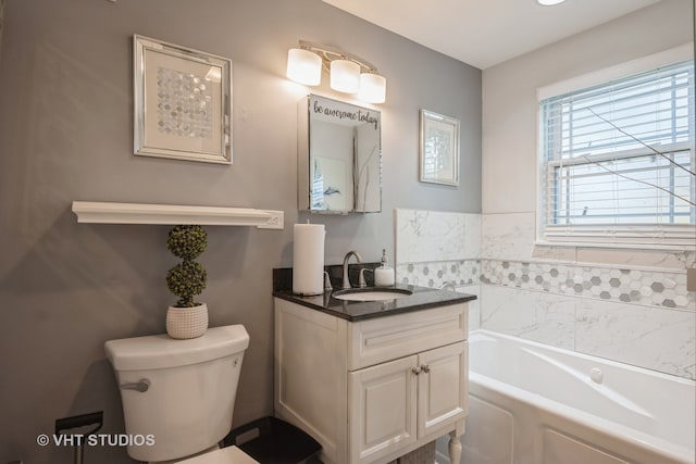 bathroom featuring a bathing tub, vanity, and toilet