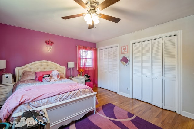 bedroom featuring light hardwood / wood-style flooring, ceiling fan, and two closets