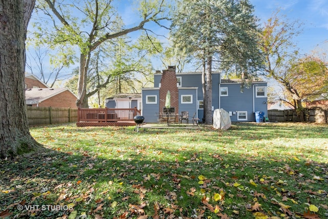 back of property with a deck and a yard