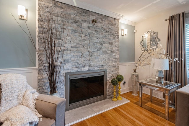 living area with hardwood / wood-style floors, a fireplace, and ornamental molding