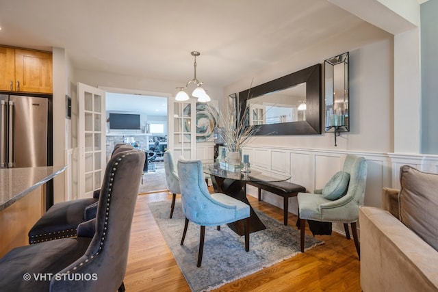 dining space with light hardwood / wood-style flooring and a notable chandelier