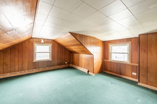 bonus room with wood walls, a wealth of natural light, vaulted ceiling, and carpet floors