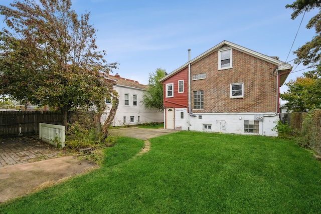 back of house with a lawn and a garage