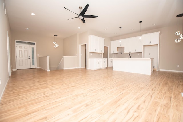 unfurnished living room featuring recessed lighting, light wood-type flooring, a ceiling fan, and baseboards