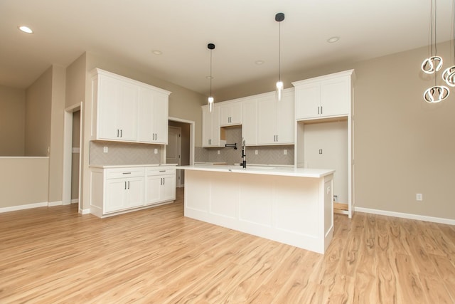 kitchen with decorative backsplash, light wood-style floors, light countertops, and recessed lighting